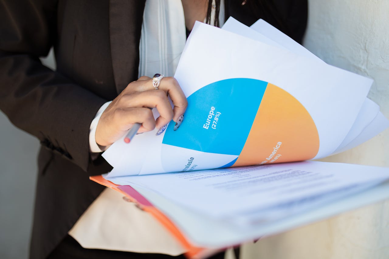 Close-up of a businesswoman reviewing financial documents with a colorful pie chart.
